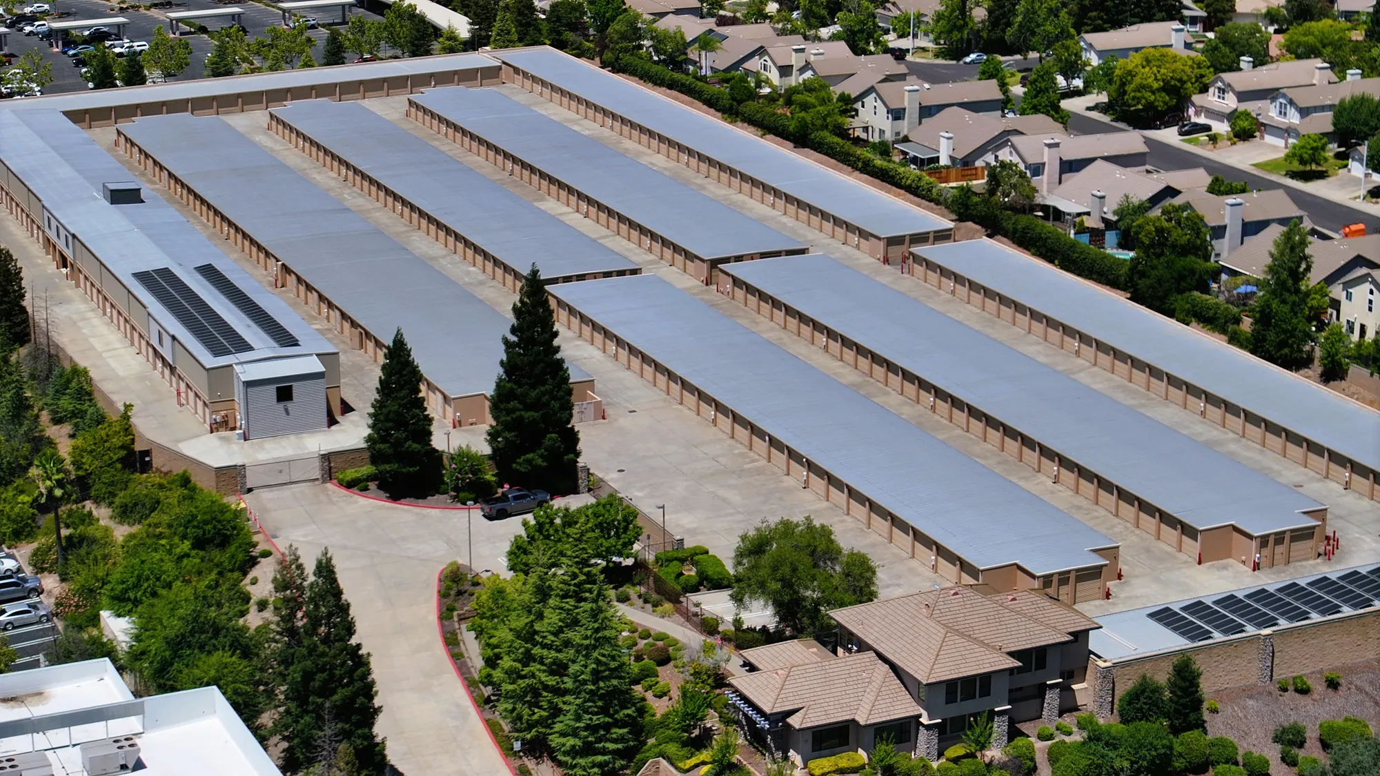 Aerial close-up of the parallel drive aisles and roll-up doors at Sierra College Self Storage, bordered by a Roseville neighborhood