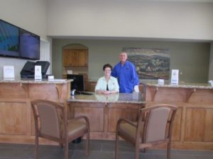 Two people standing behind front desk in lobby