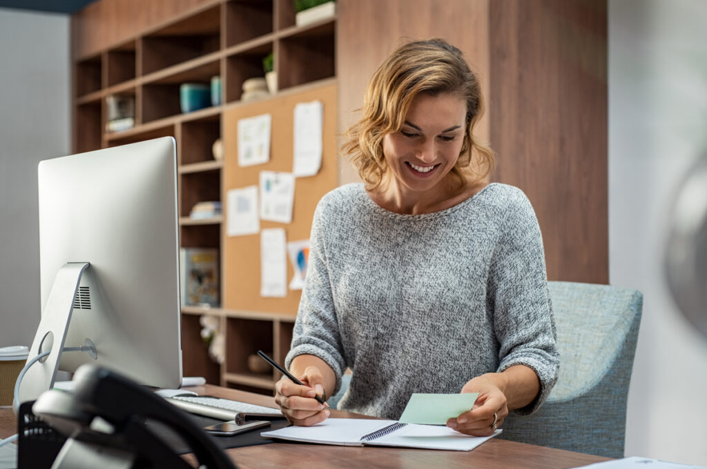 Woman smiling at desk due to self storage management options